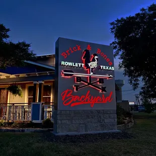 Brick &amp; Bones Backyard sign at night. Eye grabber off of Main Road!