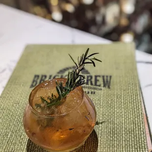 a drink with a sprig of rosemary