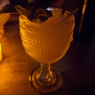 a glass with a plant in it