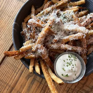 a bowl of french fries with parmesan cheese
