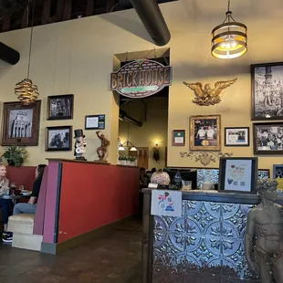 Brick House sign, hostess stand and a booth in the restaurant.