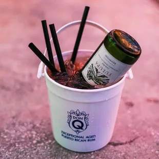 a white bucket filled with drinks and straws