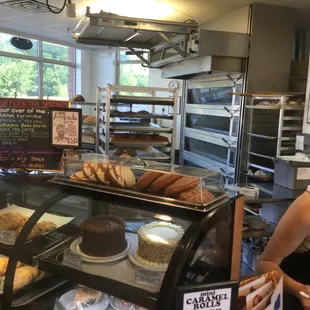 a woman standing in front of a bakery counter
