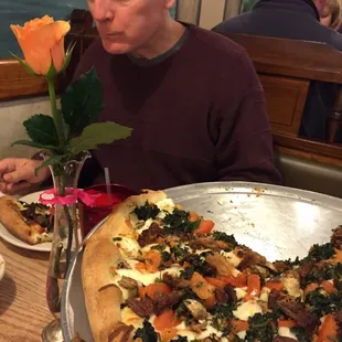 a man sitting in front of a pizza