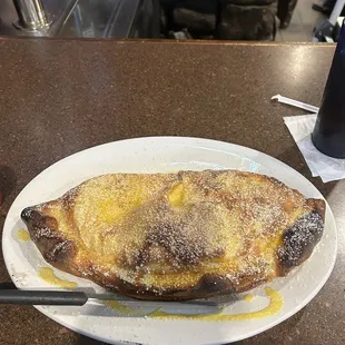 Cheese Calzone with garlic butter sprinkled with Parmesan on top. Best I ever had.