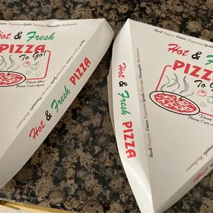 two pizza boxes on a counter