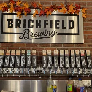 a brick wall with a metal sign above it