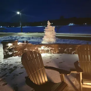 two adiron chairs in front of a fire pit