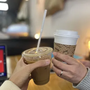 two people holding cups of coffee