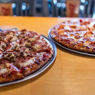 two pizzas on a table