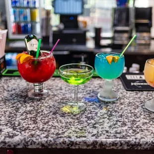 a variety of cocktails on a bar