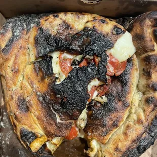 a burnt pizza in a box