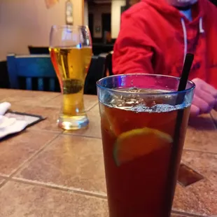 a man sitting at a table with a glass of iced tea