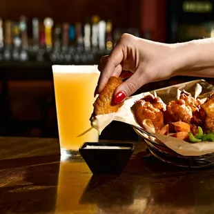 a hand grabbing a piece of fried chicken