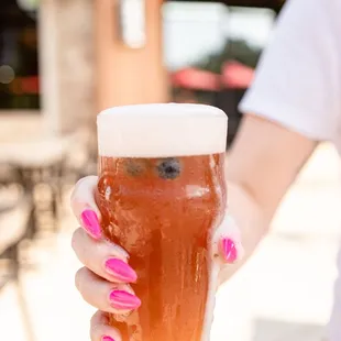 a woman holding a glass of beer