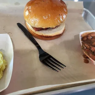 Sausage sandwich with potato salad and beans