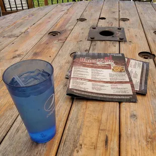 a drink and menu on a wooden table