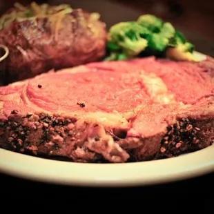 a large roast of beef with a side of broccoli