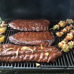 steaks and skewers on a grill