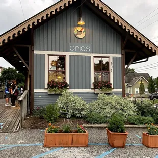 the front of a building with potted plants in front of it