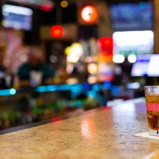 a person sitting at a bar with a drink