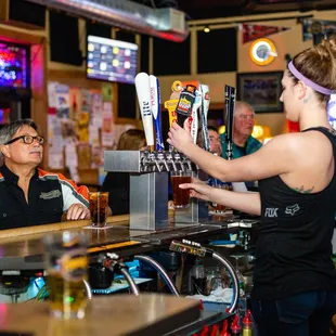 a woman serving a beer at a bar
