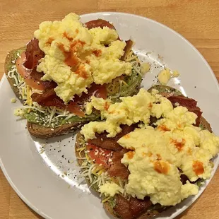 Avocado Toast on multigrain with tomatoes, eggs, bacon and shredded cheddar cheese