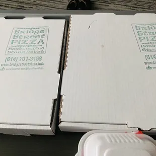 two boxes of pizza on a table