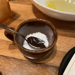 Salt brought out in a tiny cup with a tiny soon.