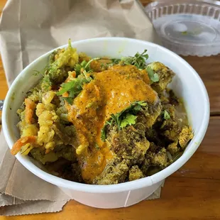 Rice bowl with lentils, peas, hakku chuala, mixed veggies, cilantro, mild sauce