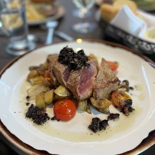 Seared tuna with olive tapenade, potatoes, tomatoes, onions