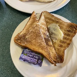 two slices of toasted bread with butter on a plate