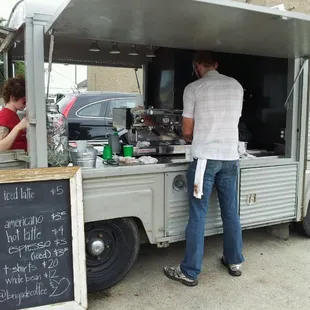 a man and a woman standing in front of a coffee truck