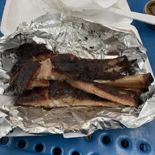 a plate of ribs wrapped in tin foil