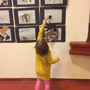One of our students pointing our their work to visitors to our spring art show.