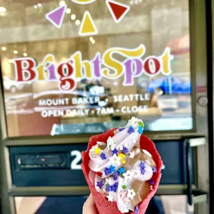 a hand holding a cone of ice cream