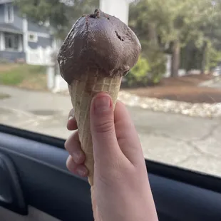 a hand holding an ice cream cone