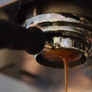 a coffee being poured into a cup