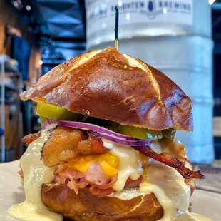 Ham and bacon sandwich with melty cheese on a pretzel bun