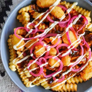 a bowl of fries with sauce and onions