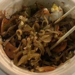 a bowl of food with chopsticks