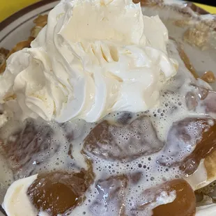 Mouth watering cinnamon apples on pancake drenched with whipped cream