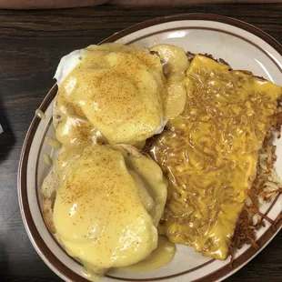 Eggs Benedict and hash browns with cheese