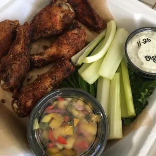 chicken wings and vegetables in a styrofoam container