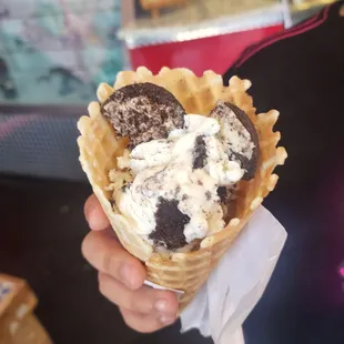 a person holding a cone of ice cream
