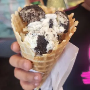 a hand holding a waffle cone