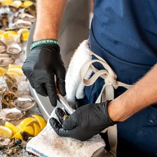 a man in a blue shirt, black gloves, and a pair of black gloves
