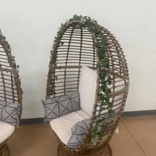 a pair of wicker chairs with cushions