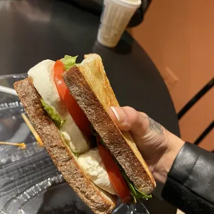 a person holding a sandwich