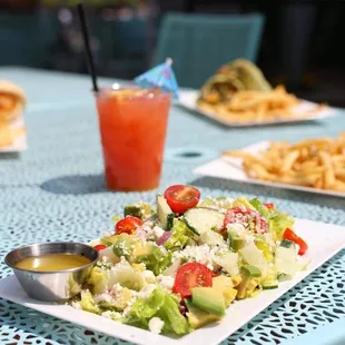 a plate of salad and a drink on a table